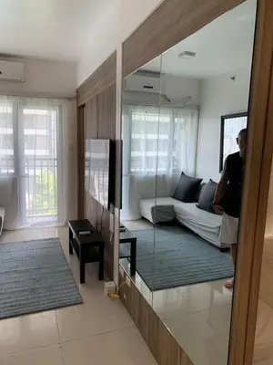 a person standing in a living room with a mirror at Fame Tower1 2-Bedrooms All Rms w Aircon Washer Balcony in Manila