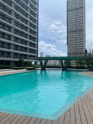 a large swimming pool with a bridge in a city at Fame Tower1 2-Bedrooms All Rms w Aircon Washer Balcony in Manila