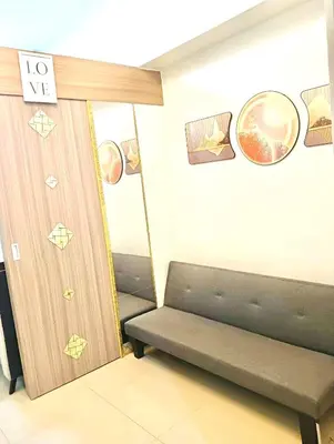 a room with a couch and a door with a sign at la Chicka - 295 T3 in Manila