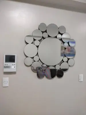 a circle of glasses on a wall with a mirror at 1 Bedroom Near Airport by Rqui in Manila