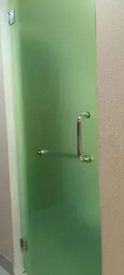 a green door with a handle in a bathroom at Shell Residence in Manila