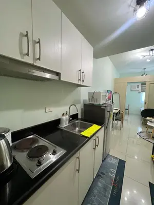 a kitchen with a stove and a sink in it at cozy green in Manila