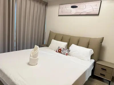 a bedroom with a bed with white sheets and pillows at Luxurious Modern Cozy Manila Bayview Pool View 1 2 3 Bedrooms Near Manila Airports Okada Solaire MOA in Manila