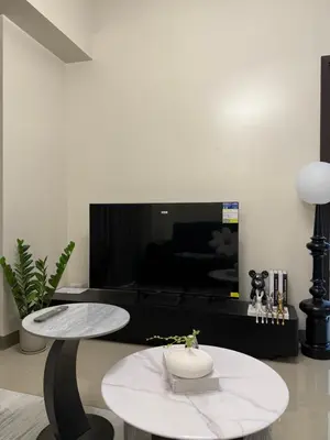 a living room with a table and a tv at Luxurious Modern Cozy Manila Bayview Pool View 1 2 3 Bedrooms Near Manila Airports Okada Solaire MOA in Manila