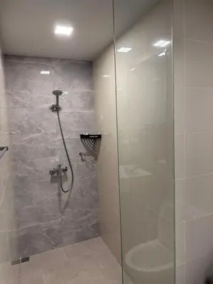 a bathroom with a shower with a glass door at Luxurious Modern Cozy Manila Bayview Pool View 1 2 3 Bedrooms Near Manila Airports Okada Solaire MOA in Manila