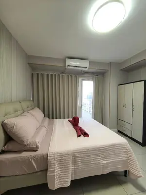 a red teddy bear sitting on top of a bed at Shell Residence Moa in Manila