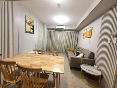 a living room with a table and a couch at Shell Residence Moa in Manila