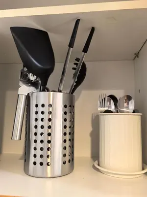 a metal container filled with utensils on a kitchen counter at Shell Residence Moa in Manila