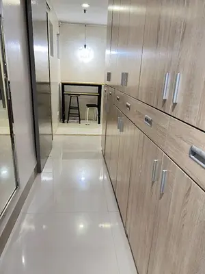 a kitchen with wooden cabinets and a table in the background at R&R Entire Rental Unit in Manila