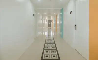 a hallway with white walls and a long line of floors at Sans Hotel near Enchanted Kingdom Santa Rosa Laguna in Santa Rosa