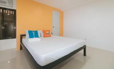 a bed in a room with orange and blue pillows at Sans Hotel near Enchanted Kingdom Santa Rosa Laguna in Santa Rosa