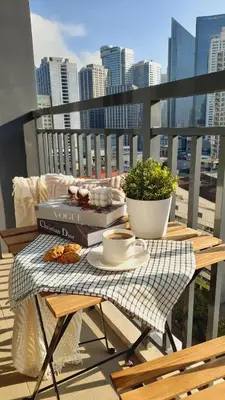 a table with books and a plate of food on a balcony at The Makati Suites at Red Residences, Premium Studio, City View, Makati CBD, Wi-fi in Manila