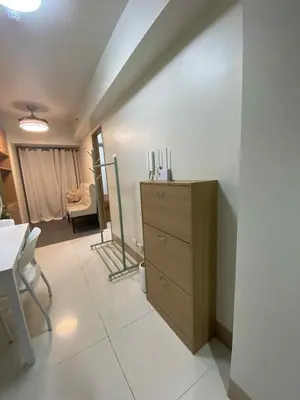 a room with a dresser and a room with a chair at Shore Condotel pasay manila in Manila