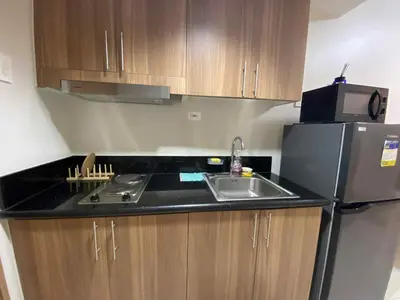 a small kitchen with a sink and a refrigerator at Shore Condotel pasay manila in Manila