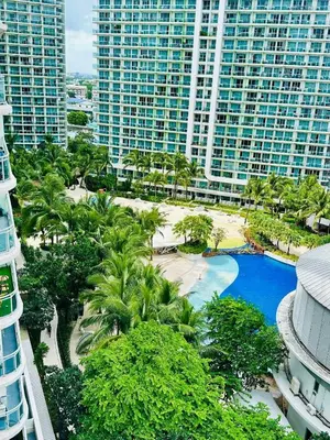 an aerial view of a resort with a pool and palm trees at Room at SM Bicutan GJ in Manila