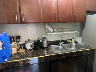 a kitchen counter with a sink and a refrigerator at Spacious 2 Bed & 2 Bath Condo in Newport City in Manila