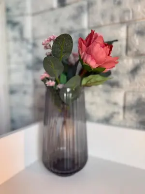 a vase with a red rose sitting on a table at Elegant Stay in Shell Residences Tower A by One Guest Place in Manila