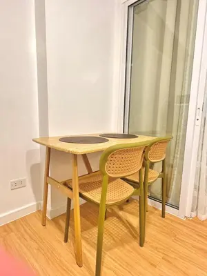 a wooden table and two chairs and a table and a window at 1BR with Pool View Near NAIA Long Stay Ready in Manila