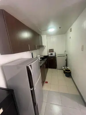 a small kitchen with a stainless steel refrigerator at A Venue Residences 1509 in Makati