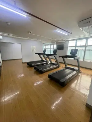 a row of treadmills in a gym with wood floors at Antel Spa Residences 9D in Makati