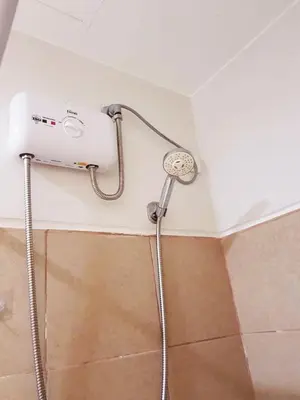 a shower in the corner of a bathroom at My little Apartment in Manila