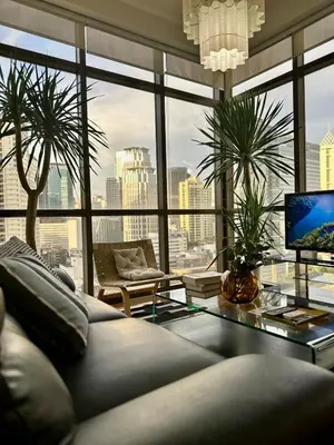 a living room with a couch and a large window at 1BR Corner Unit with Balcony in Manila