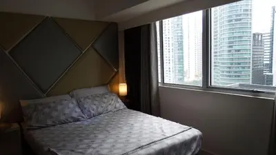 a bedroom with a bed and a large window at Urban Nest in Manila
