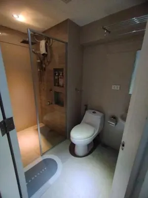 a small bathroom with a toilet and a shower at Urban Nest in Manila