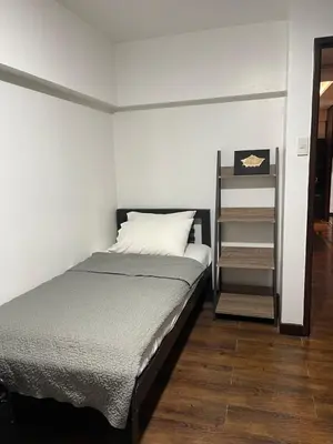 a bedroom with a bed and a book shelf at Spacious 3BR with Huge TV near BGC Makati Airport in Manila