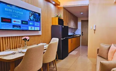 a dining room with a table and a kitchen with a tv at Elegant with Best View Fast Wifi Mall of Asia Airport in Manila
