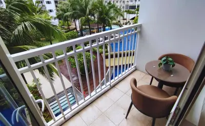 a balcony with a table and chairs and palm trees at Elegant with Best View Fast Wifi Mall of Asia Airport in Manila