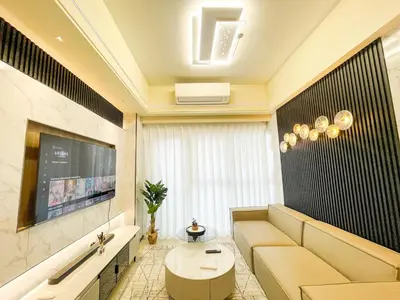 a living room with a couch and a tv at Lovely & Luxury 1BR near Solaire, Okada w Sunset in Manila