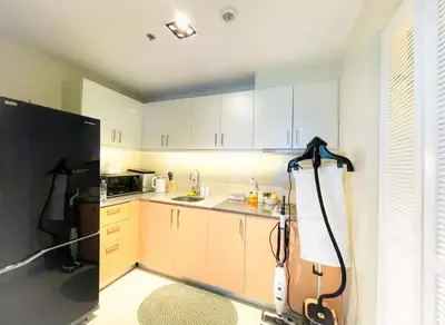 a kitchen with white cabinets and a black refrigerator at Spacious 3BR near Solaire, Okada, Airport I 8pax in Manila