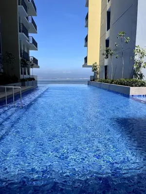 a swimming pool in the middle of two buildings at Spacious 2BR near Solaire, Okada, Airport in Manila