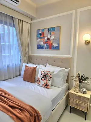 a bedroom with a bed with pillows and a window at Luxury Condotel Manila by MOA in Manila