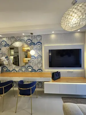 a living room with a tv and a table and chairs at Luxury Condotel Manila by MOA in Manila
