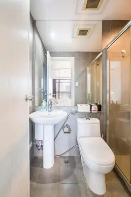 a bathroom with a toilet and a sink at 1 Bedroom Loft in Gramercy Residences Makati in Manila