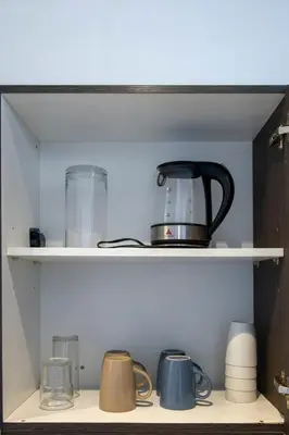 a shelf with a tea pot and other items on it at 1 Bedroom Loft in Gramercy Residences Makati in Manila
