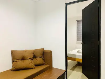 a mirror next to a couch in a room at The Seaside Residences in Manila