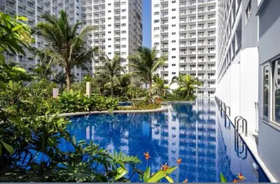 a swimming pool in the middle of a city with tall buildings at Shore Residences Mall of Asia in Manila