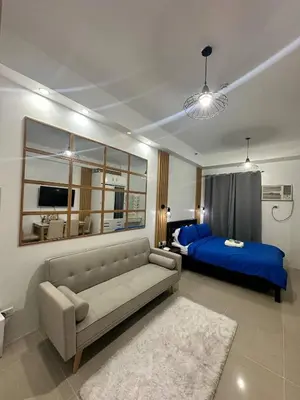 a living room with a couch and a bed at Shore Residences Mall of Asia in Manila