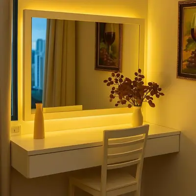 a table with a mirror and a chair and a vase with flowers at Skyline escape luxury makati gym swim parking 4649 in Manila
