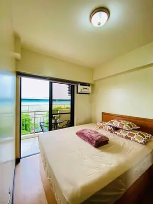 a bedroom with a bed with a view of the ocean at 2BR FREE PARKING Calathea Place in Manila