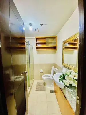 a bathroom with a toilet and a sink and a shower at 2BR FREE PARKING Calathea Place in Manila