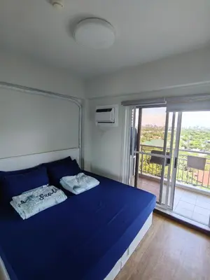 a bedroom with a blue bed and a balcony at The Atherton by DMCI- 2BR FREE PARKING in Manila