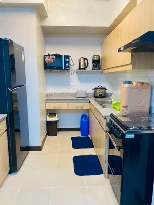 a kitchen with a stove and a refrigerator at The Atherton by DMCI- 2BR FREE PARKING in Manila