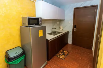a small kitchen with a refrigerator and a sink at SkyVista Luxe Makati Staycation Pool Gym Netflix 5637 in Manila