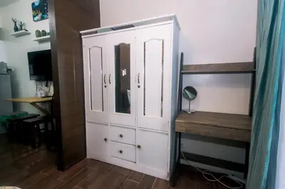 a bedroom with a white cabinet and a desk at The Giggle Spot Cozy Makati Hideaway Pool & Gym 2270 in Manila