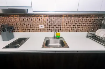 a kitchen with a sink and a counter top at The Giggle Spot Cozy Makati Hideaway Pool & Gym 2270 in Manila