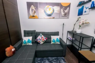 a living room with a couch and pillows at The Giggle Spot Cozy Makati Hideaway Pool & Gym 2270 in Manila